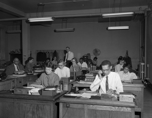 People at desk in office circa 1955